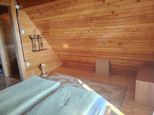 a room with a bed in a wooden wall at Aurora Tara 1 in Bajina Bašta