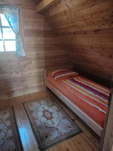 a bedroom with a bed in a wooden cabin at Aurora Tara 1 in Bajina Bašta