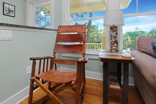 a wooden chair sitting next to a table in a living room at Attitude Adjustment by Pristine Properties Vacation Rentals in Indian Pass