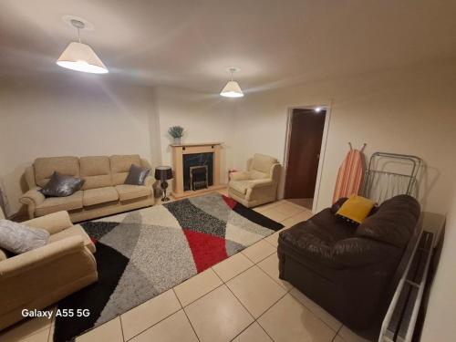 a living room with two couches and a fireplace at Gala House in Lurgan