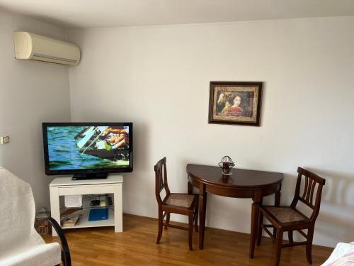 a living room with a table and a flat screen tv at Apartman KalaMar in Crikvenica