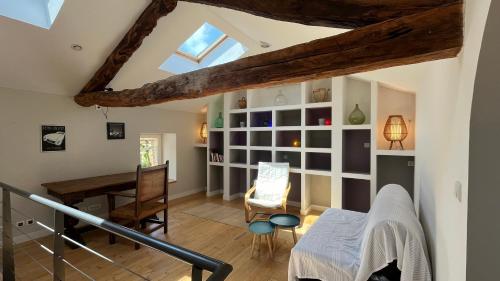 a room with a loft with a desk and a table at Maison de campagne au calme in Mouzieys-Panens