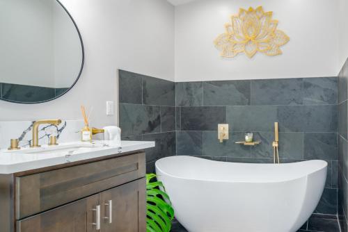 a bathroom with a tub and a sink and a mirror at 5-Star Luxury Sauna-Spa Retreat Near Volcano Nat'l in Volcano