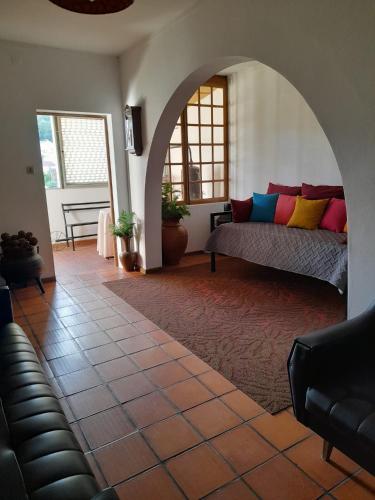 Sala de estar con cama con almohadas coloridas en AlojamentoGodimDouro, en Peso da Régua