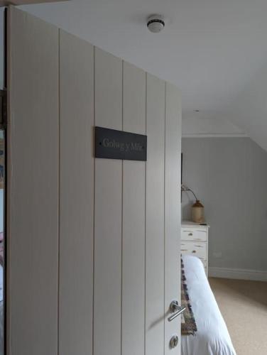 a white cabinet with a sign on top of it at Pencartref Apartment - 4 Bedrooms, 3 Bathrooms, Sleeps 7-8 in Aberdyfi