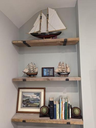 a shelf with a model ship and books at Pencartref Apartment - 4 Bedrooms, 3 Bathrooms, Sleeps 7-8 in Aberdyfi