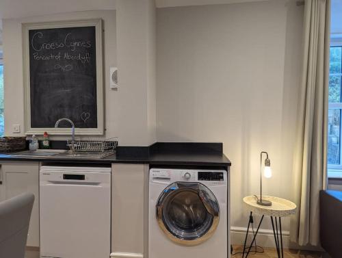 a kitchen with a washing machine and a sink at Pencartref Apartment - 4 Bedrooms, 3 Bathrooms, Sleeps 7-8 in Aberdyfi