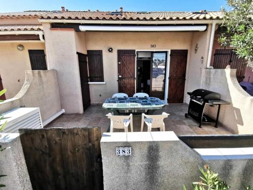 un patio avec une table et des chaises devant une maison dans l'établissement Résidence Grande Bleue - VILLA 3 MEZZANINE PIECES 6 couchages PORT LEUCATE. Réf: 3GB_383 MAE-7101, à Leucate
