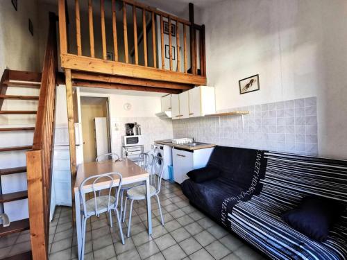 Il comprend un salon avec une table et un lit ainsi qu'une cuisine. dans l'établissement Résidence Grande Bleue - VILLA T1 CAB MEZZ 6 couchages PORT LEUCATE MAE-7111, à Leucate