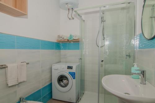 un bagno con lavatrice e lavandino di Casa Lillì a Ischia