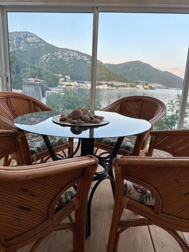 a table with a plate of food sitting on it in front of a window at Apartman PITOSPORA in Klek