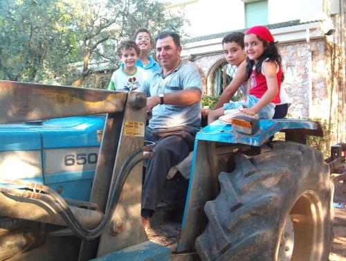 a group of people sitting on a toy tractor at Agriturismo Valle Verde in Altamura