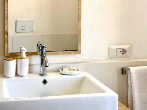 a white sink in a bathroom with a mirror at Casa Zagami in Malfa