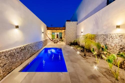 an indoor pool with blue water in a house at Casa mi Merida Centro, alberca, tina, cuarto king size, cuarto 2 camas dobles in Mérida