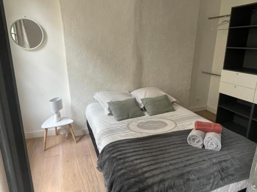 une chambre avec un lit avec deux serviettes dessus dans l'établissement Appartement Cosy - Coeur de ville, à Agen
