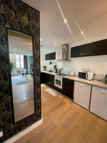 - une cuisine avec un grand miroir dans la chambre dans l'établissement Appartement Cosy - Coeur de ville, à Agen