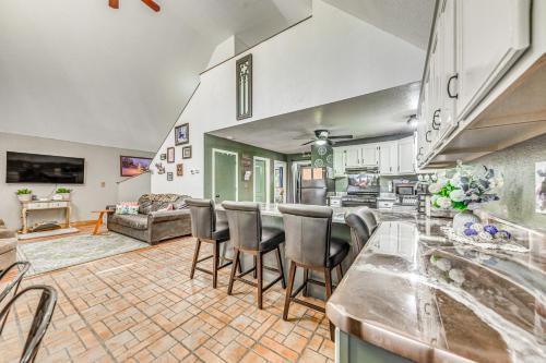 a kitchen and living room with a bar and chairs at Quaint Cloudcroft Cabin with Stunning Forest Views! in Cloudcroft