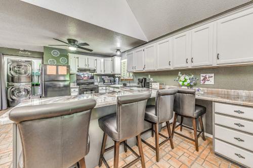 a kitchen with white cabinets and bar stools at Quaint Cloudcroft Cabin with Stunning Forest Views! in Cloudcroft