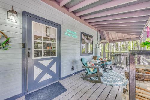 a front porch with a blue door and chairs at Quaint Cloudcroft Cabin with Stunning Forest Views! in Cloudcroft