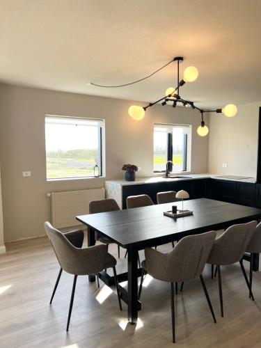 a dining room with a black table and chairs at The Greyhouse "Big Apartment" in Höfn