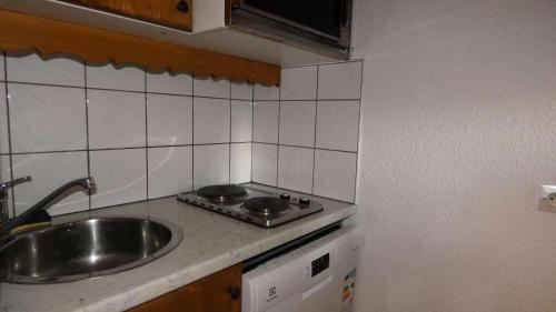 une petite cuisine avec un évier et une cuisinière dans l'établissement Résidence Roche Combe - Le Roche Combe 10 - Agréable studio divisible offrant une magnifique vue sur la vallée MAE-4984, à Valmorel