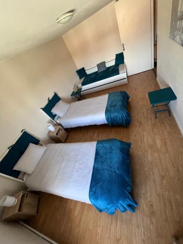 - une chambre avec 2 lits dotés d'oreillers bleus dans l'établissement Maison entre campagne et ville proche Futuroscope, à Neuville-du-Poitou