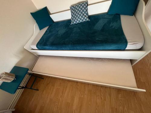 a small bed in a small room with blue pillows at Maison entre campagne et ville proche Futuroscope in Neuville-de-Poitou