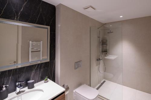 a bathroom with a shower and a toilet and a sink at Luxury apartment with Pool&Gym in Belgrade