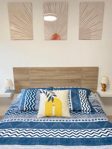 畢斯卡斯的住宿－Apartamento Espert Biescas，一间卧室配有一张带蓝色和白色枕头的床
