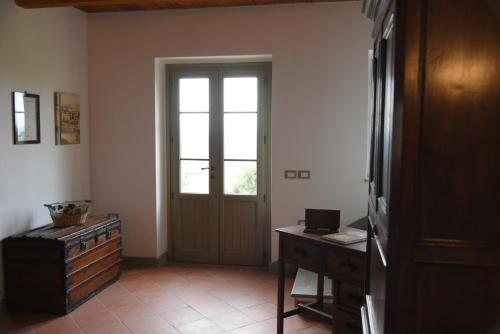 a room with a door and a table and a desk at La Casa Nel Bosco in Ripatransone