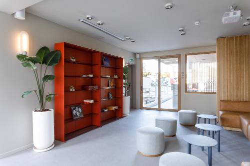 a living room with tables and chairs and a book shelf at Bromelia Hotel Boutique in Buenos Aires