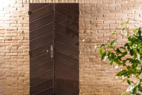 a wooden door on the side of a brick wall at La Casa Nel Bosco in Ripatransone