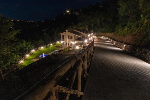 a bridge over a river at night with lights at La Casa Nel Bosco in Ripatransone