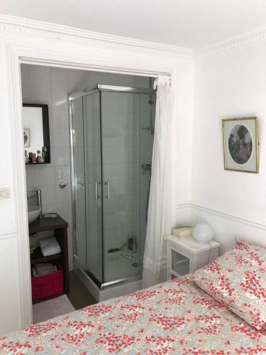 une chambre avec douche et un lit avec un couvre-lit dans l'établissement Appartement Cosy - Abbesses Montmartre, à Paris