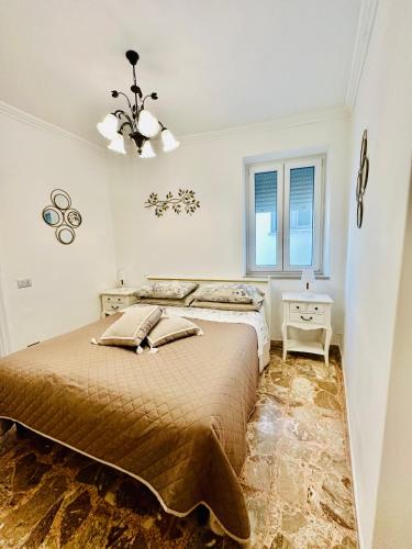 Habitación blanca con cama y lámpara de araña. en Capri Joy, en Capri