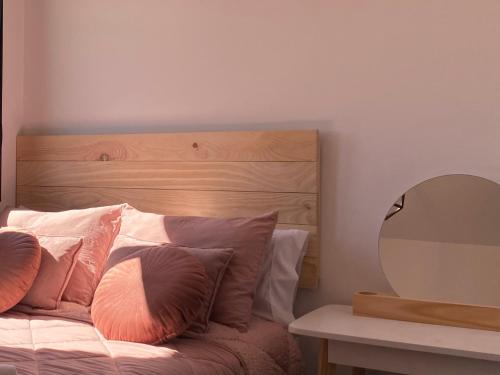 una camera da letto con letto, testiera e cuscini in legno di Torre Luxor a León