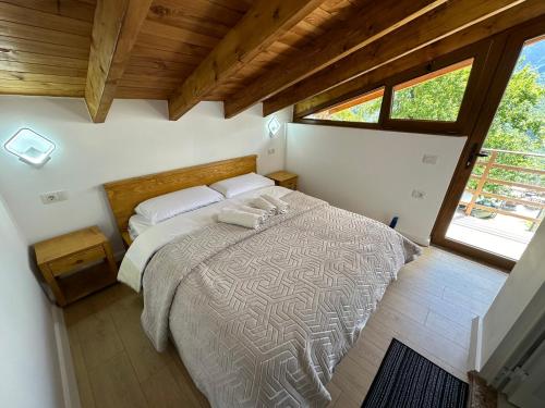 a bedroom with a large bed in a room with a window at Bujtina Carku in Theth