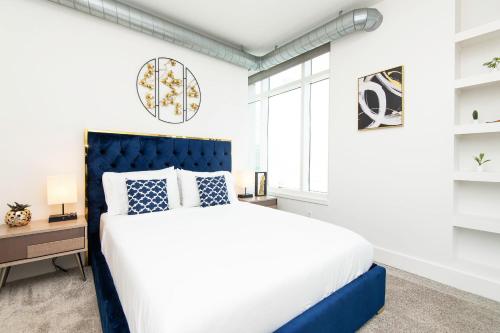 a bedroom with a large bed with a blue headboard at Sky-Rise Apartments in Los Angeles