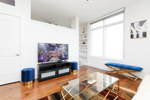 a living room with a tv and a glass table at Sky-Rise Apartments in Los Angeles