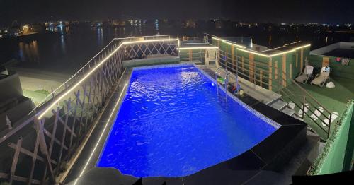 una piscina en la parte superior de un edificio por la noche en منتجع اووه يامال البحري في الخيران OOh Yaa Mal en Al Khīrān
