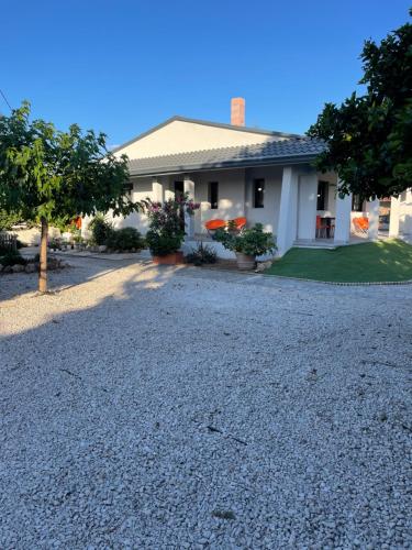 a house with a gravel driveway in front of it at Casa Posidonia in Korinthos