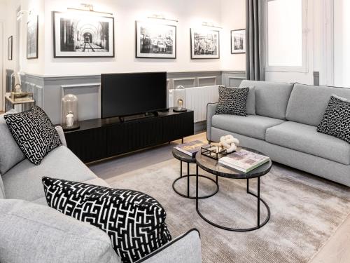 un salon avec un canapé et une télévision dans l'établissement LivinParis - Luxury AC 4 Bedrooms Auteuil Eiffel, à Paris