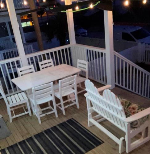 een houten tafel en stoelen op een veranda met een tafel en stoelen bij Oleander Place by Pristine Properties Vacation Rentals in Mexico Beach