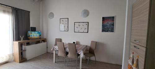 a dining room with a table and chairs and a television at Cascina Boroardo D4 in Cremona