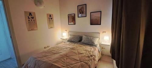a bedroom with a bed with three pictures on the wall at Cascina Boroardo D4 in Cremona