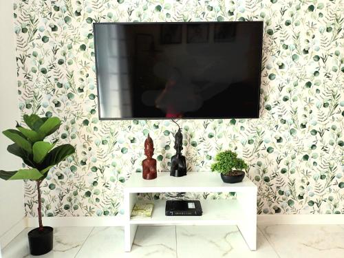 a flat screen tv on a wall with a white table at Apartament Ania Stare Miasto in Elblag