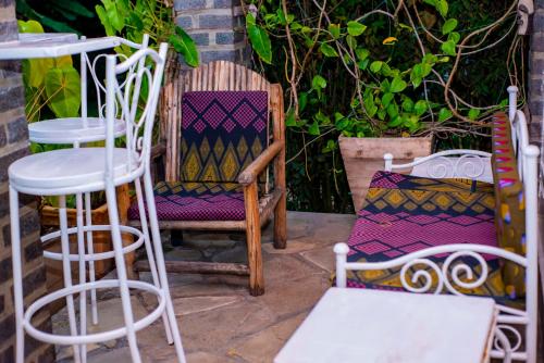 a group of chairs and stools sitting on a patio at Little Birds Paradise in Ruhengeri
