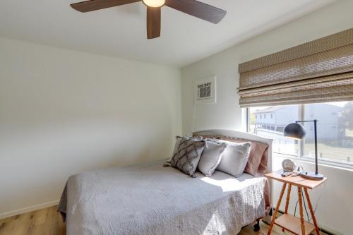 a bedroom with a bed with a ceiling fan and a window at Pet-Friendly Oak Harbor Condo Walk to Lake! in Sand Beach