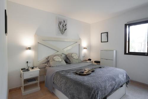 een witte slaapkamer met een groot bed en een raam bij Private Chalet - Fast Wi-Fi - Pool in Corralejo