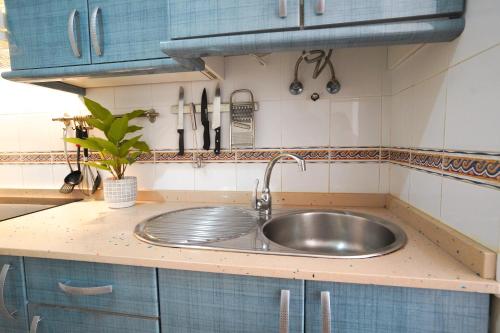 een gootsteen in een keuken met blauwe kasten bij Private Chalet - Fast Wi-Fi - Pool in Corralejo